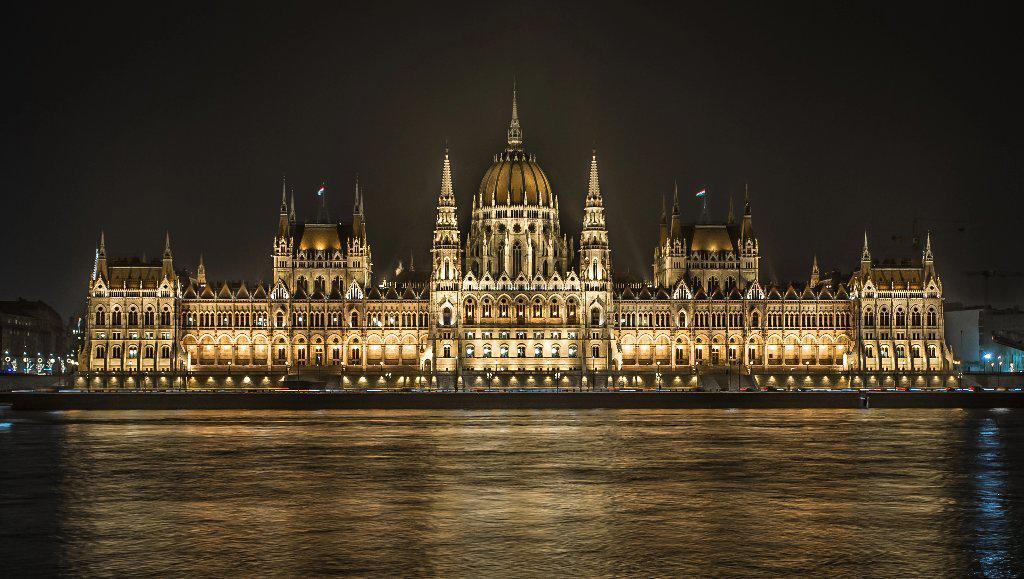 Fine photographic and art print of the Hungarian Parliament building in Budapest at nighttime with the light reflecting on the Danube River.