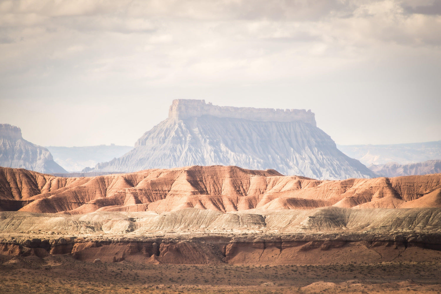 Fine Grand Staircase Escalante National Monument photography print of the massive rock formations dwarfing the expansive mountains in the foreground.