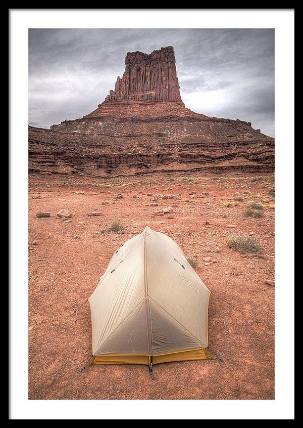 Framed fine photographic and art print of a small backpacker's tent in front of a red stone monument along Canyonlands National Park's White Rim Trail in Utah.