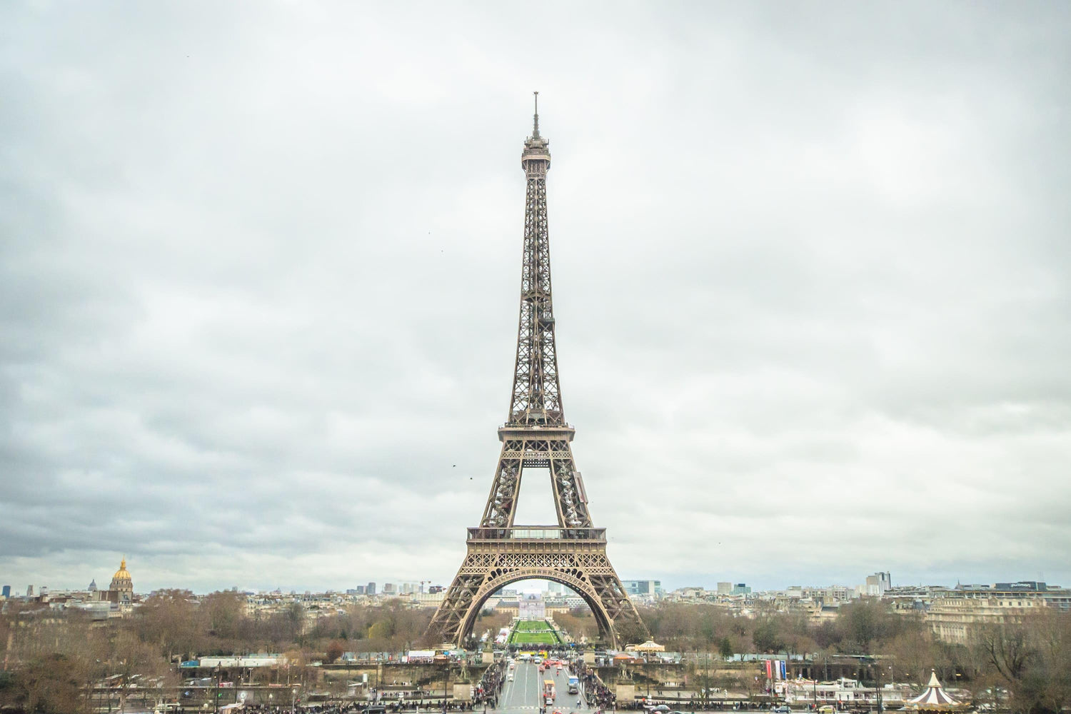 Fine photographic and art print of the Eiffel Tower in the distance with a cloudy backdrop over the landscape of Paris France.