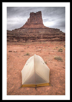 Framed fine photographic and art print of a small backpacker's tent in front of a red stone monument along Canyonlands National Park's White Rim Trail in Utah.