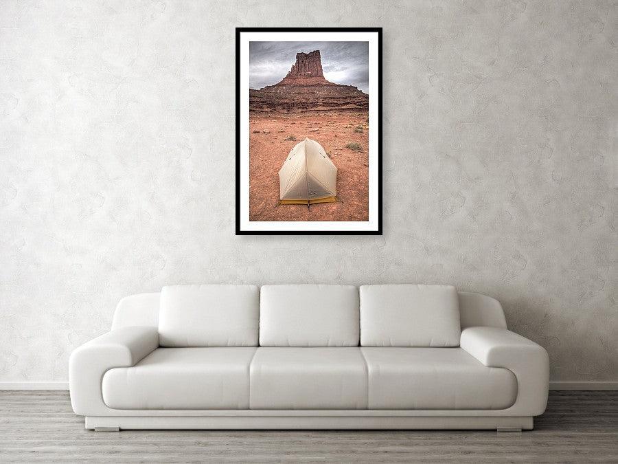 Framed fine photographic and wall art print of a small backpacker's tent in front of a red stone monument along Canyonlands National Park's White Rim Trail in Utah.