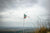 Fine photographic and art print of a ripped Democratic Republic of the Congo flag on top of a mountain overlooking a small village. 