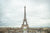Fine photographic and art print of the Eiffel Tower in the distance with a cloudy backdrop over the landscape of Paris France. 