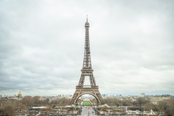 Fine photographic and art print of the Eiffel Tower in the distance with a cloudy backdrop over the landscape of Paris France. 
