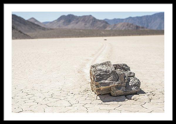 Framed fine photographic and art print of a single jagged rock carving a mysterious path through a cracked desert floor in Death Valley National Park in California.