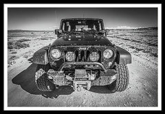 Framed fine black and white photographic and art print of a black Jeep Wrangler off-road driving along the White Rim Trail of Canyonlands National Park near Moab, Utah.