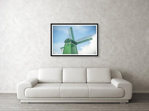 Framed fine photographic and wall art print of a single green windmill against a backdrop of blue dutch skies.