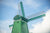 Fine photographic and art print of a single green windmill against a backdrop of blue dutch skies.